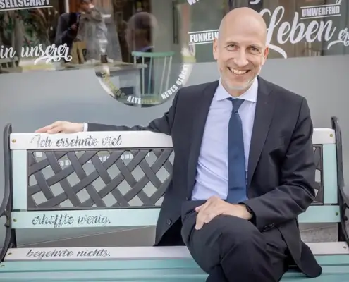 Bundesminister Univ.-Prof. Dr. Martin Kocher eröffnete am 23. Mai 2022 den neuen Standort von frauenanderskompetent, hier auf einem der upgecycelten Werkstücke von FunkelNagel. 