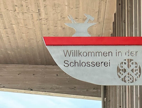 Ein modern interpretiertes Zunftzeichen an der Schlosserei.