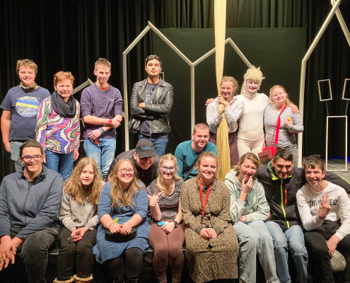 Gruppe junger Menschen mit Pädagogin und SchaulspielerInnen auf Theater-Bühne