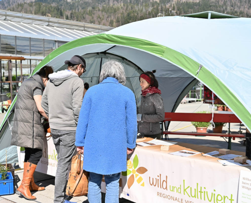 Menschen im Gespräch an Infostand „wild und kultiviert“ beim Salzburger Wildgehölztag