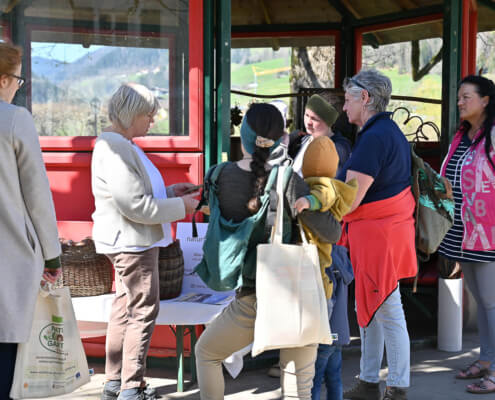 Mehrere Menschen im Gespräch an einem Stand im Freien, Inklusion, soziale Teilhabe, Salzburg