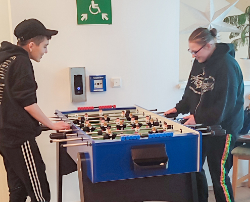 Zwei junge Menschen spielen Tischkicker in einer Wohngemeinschaft für selbstbestimmtes Leben