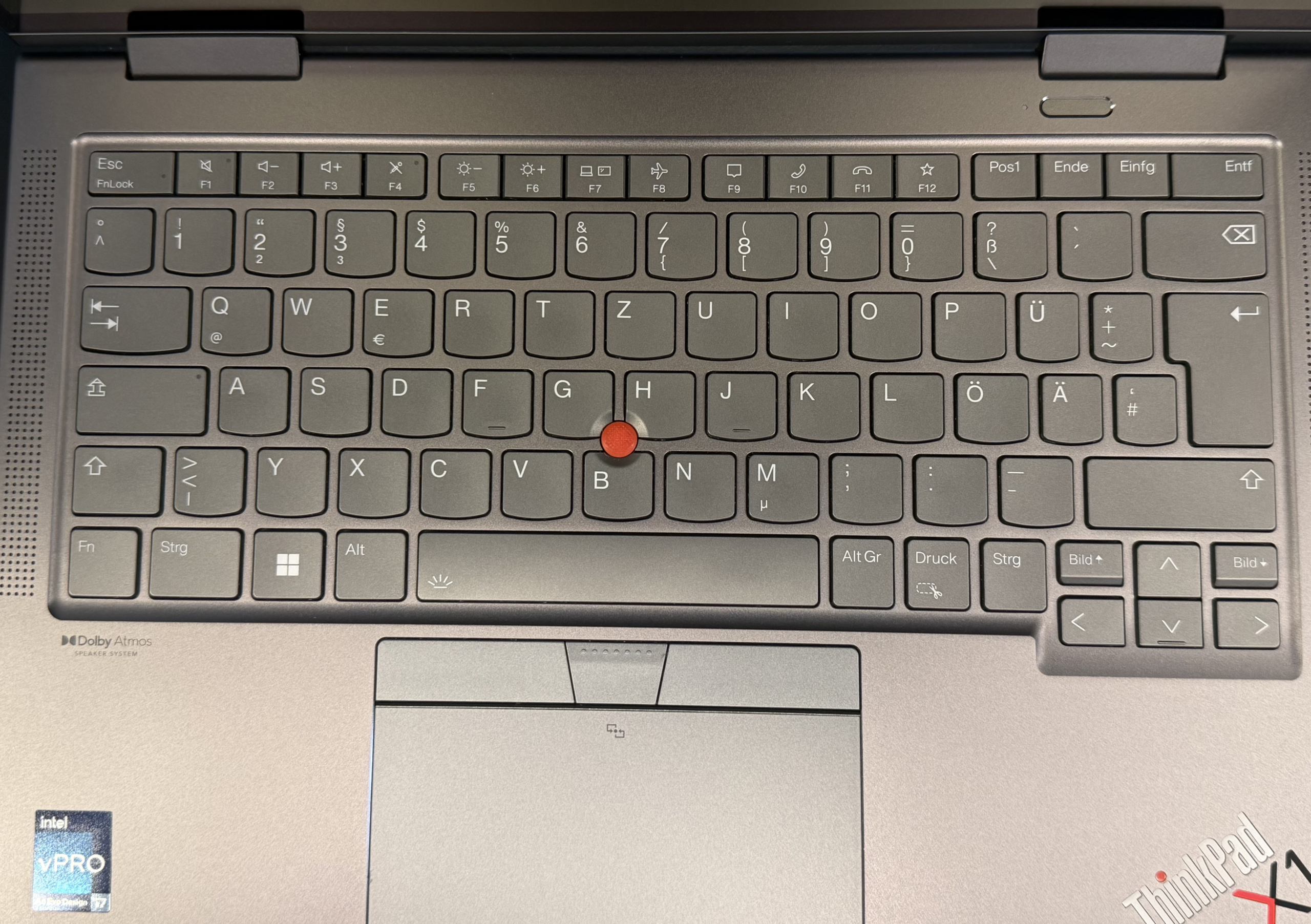 Nahaufnahme einer Laptop-Tastatur mit deutschem Layout, rotem Trackpoint und Touchpad