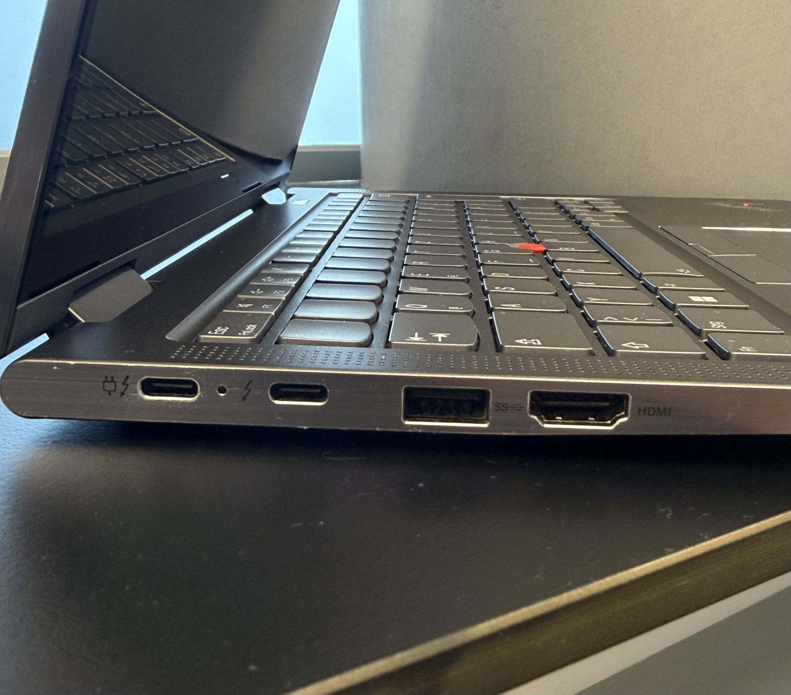 Nahaufnahme eines schwarzen Laptops mit Tastatur, Bildschirmkante und seitlichen Anschlüssen